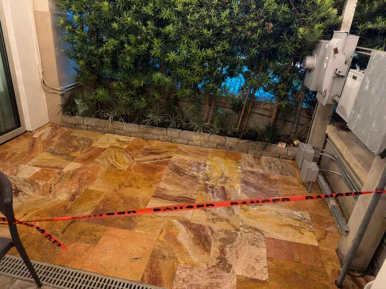 Close view of freshly sealed gold and amber travertine at a commercial restaurant patio