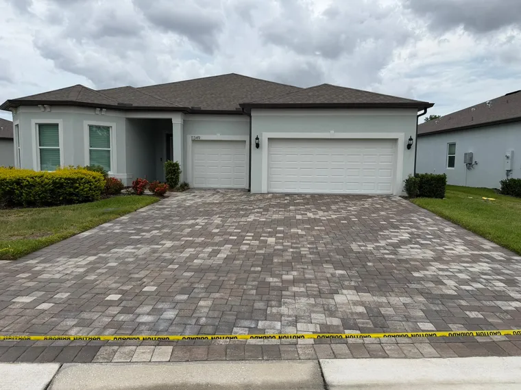 Completed paver driveway sealing job taped off at the apron while the sealer cures