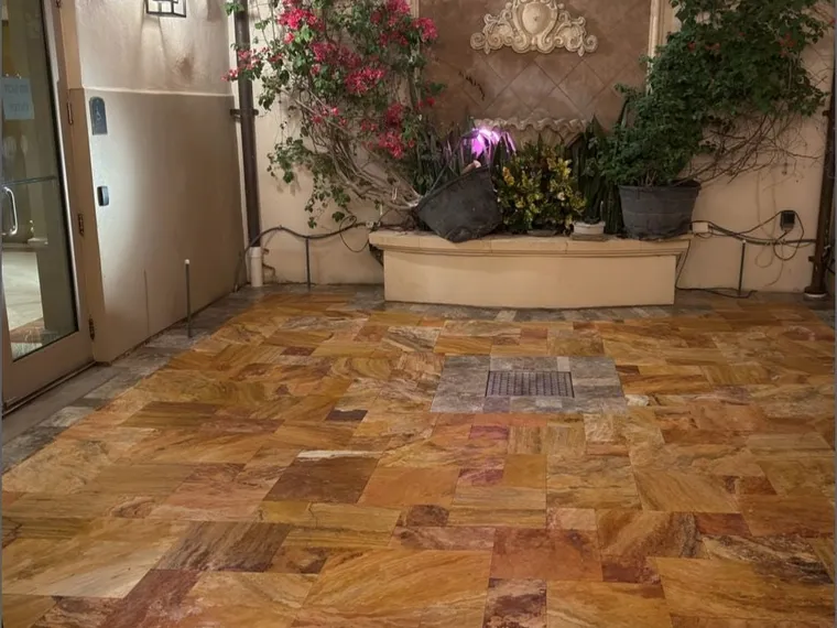 Interior courtyard with a fountain and flowering vines over a freshly sealed travertine floor